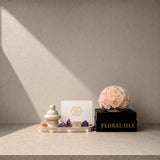 Editorial lifestyle view of a travertine saucer rose arrangement as a centerpiece on a minimalist stone table