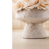 Detailed texture of a hand-crafted porous travertine stone pedestal vase for high-end preserved flower packaging.
