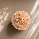 Low-slung natural travertine stone bowl with perfectly arranged champagne preserved roses