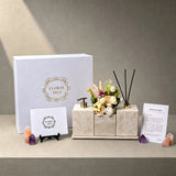 Gallery-style entryway decor showcasing a continuous trio-stone layout on a white gift box by Floral Isle.