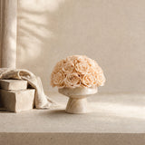 Wabi-sabi style travertine stone everlasting rose floral arrangement styled on a modern farmhouse concrete console table.