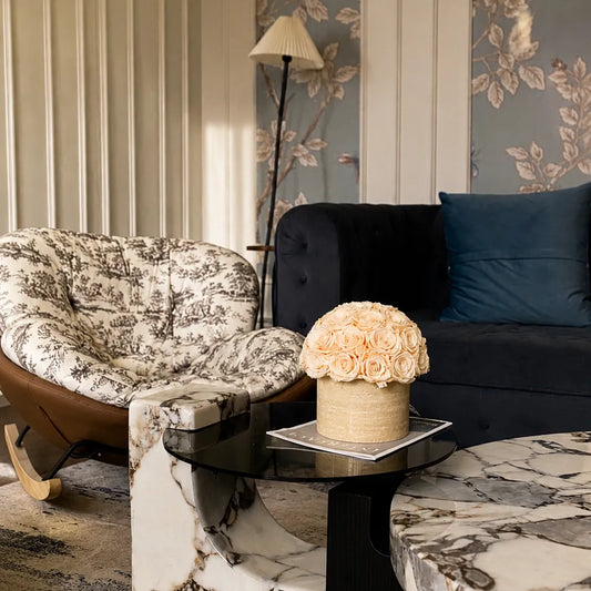 Elegant preserved flowers with warm travertine and natural wood elements creating a calming luxury home interior