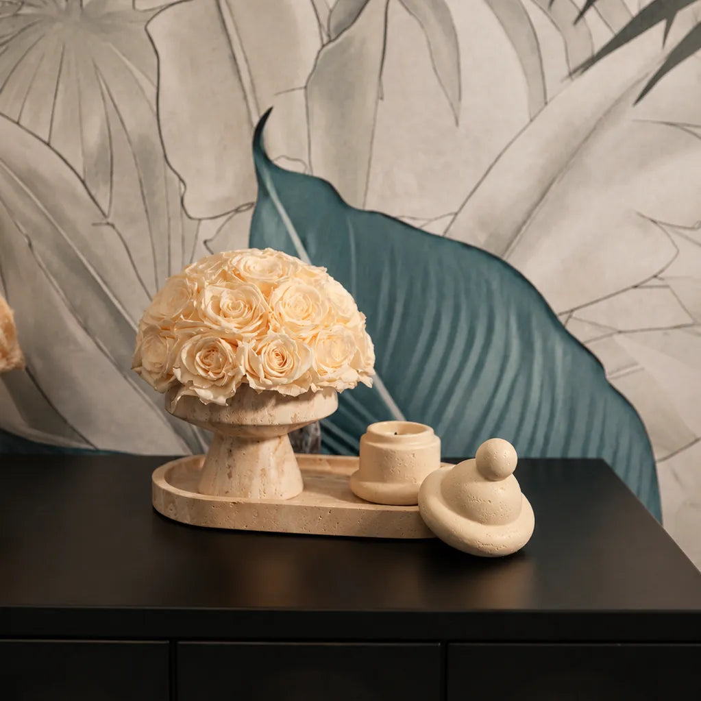 Timeless luxury home interior featuring preserved flowers in a travertine vase with natural textures and minimalist design