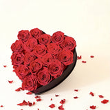A luxurious heart box filled with 13 or 20 handcrafted forever roses, featuring a Parisian black hat-box design with gold detailing. Bloom 3+ years.