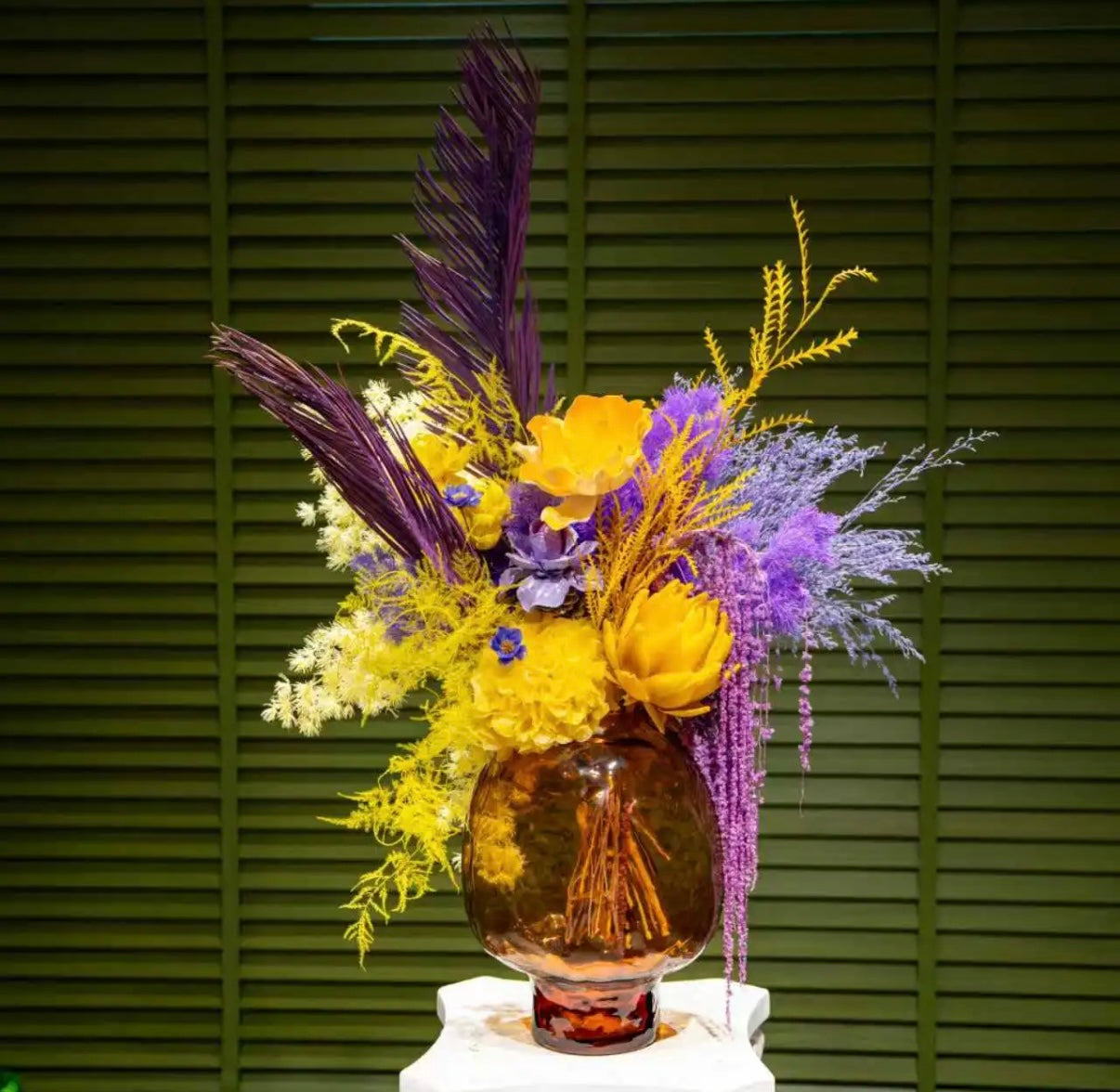 Luxury preserved flower arrangement featuring vibrant yellow and purple eternal blooms in an amber glass vase. Elegant modern floral decor by Floral Isle, perfect for home décor, weddings, or anniversary gifts.