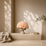Editorial lifestyle view of a sculptural travertine centerpiece with earthy eternal flowers in a minimalist interior.