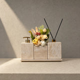 Wabi-sabi home decor piece featuring weathered yellow travertine ores and everlasting flowers on a entryway console.